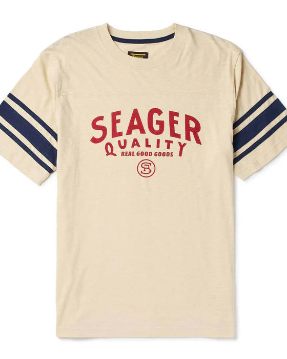 Beige t-shirt with red 'Seager' logo and blue stripes on sleeves against a white background
