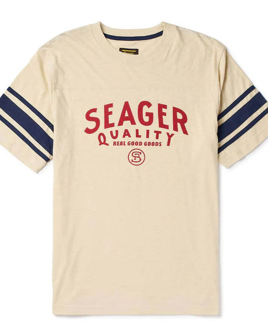 Beige t-shirt with red 'Seager' logo and blue stripes on sleeves against a white background